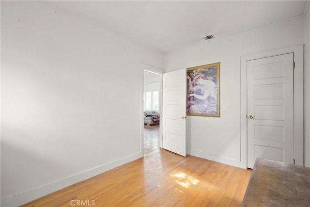 spare room featuring visible vents, light wood-style flooring, and baseboards