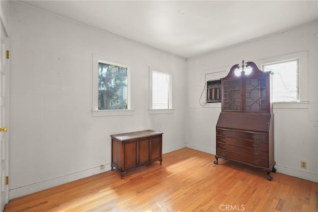 empty room with a wealth of natural light, light wood-style flooring, and baseboards