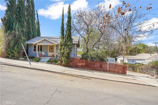 view of front of home featuring covered porch and a fenced front yard