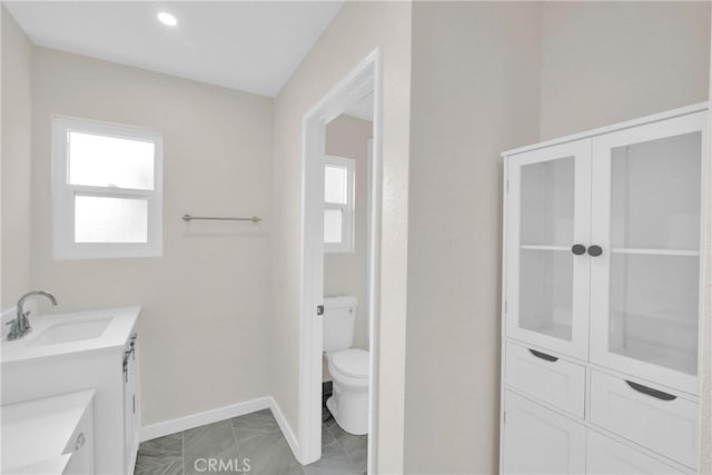 bathroom featuring vanity, toilet, and baseboards