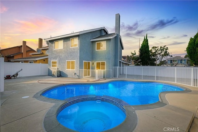 view of pool featuring a patio area, a fenced backyard, and a pool with connected hot tub