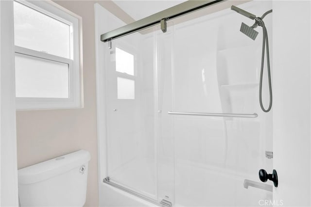 bathroom with toilet and a shower with door