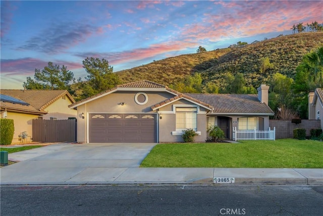 view of front of home with stucco siding, a tiled roof, and fence