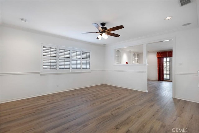 spare room featuring a ceiling fan, visible vents, crown molding, and wood finished floors