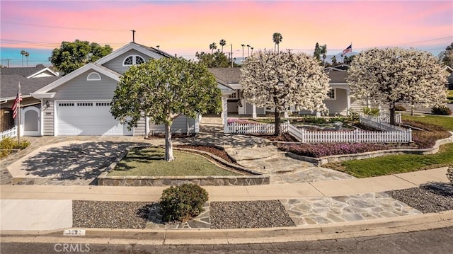 view of property hidden behind natural elements with driveway, an attached garage, and fence