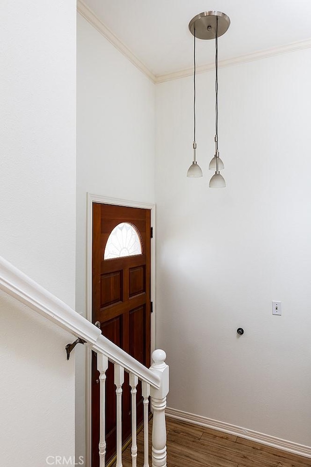 foyer entrance with baseboards, stairway, wood finished floors, and crown molding