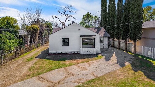 exterior space with brick siding, roof with shingles, and fence private yard