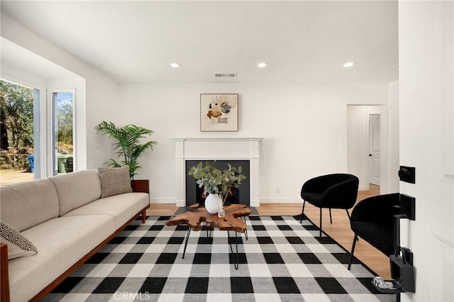 living area with baseboards, a fireplace, visible vents, and recessed lighting