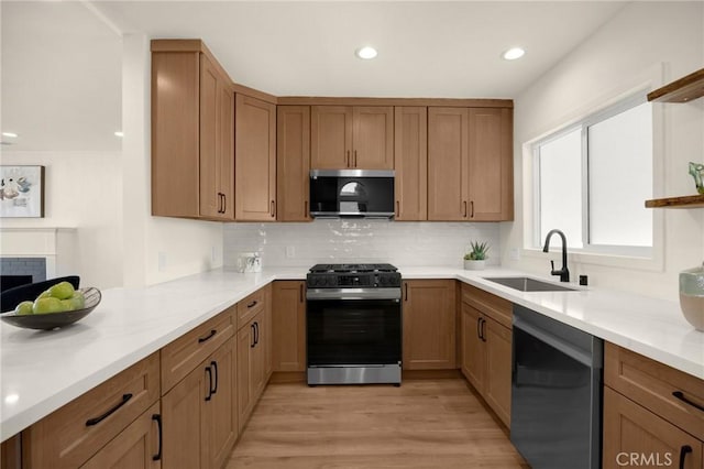 kitchen with backsplash, a fireplace, stainless steel appliances, and a sink