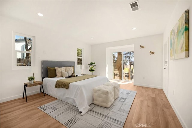 bedroom featuring access to exterior, baseboards, visible vents, and light wood finished floors