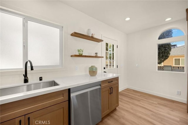 kitchen featuring light wood-style flooring, light countertops, stainless steel dishwasher, a sink, and recessed lighting