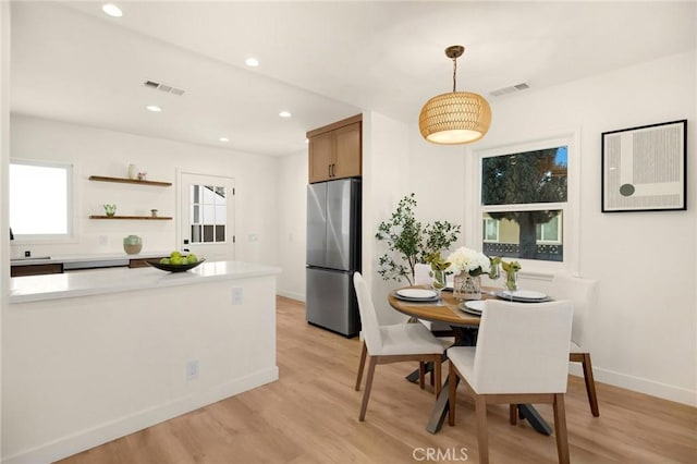 dining space featuring light wood-type flooring, a healthy amount of sunlight, visible vents, and recessed lighting