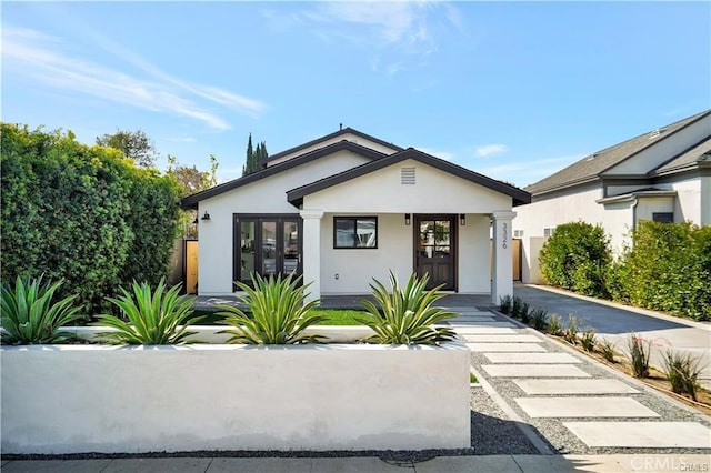 bungalow-style house with stucco siding