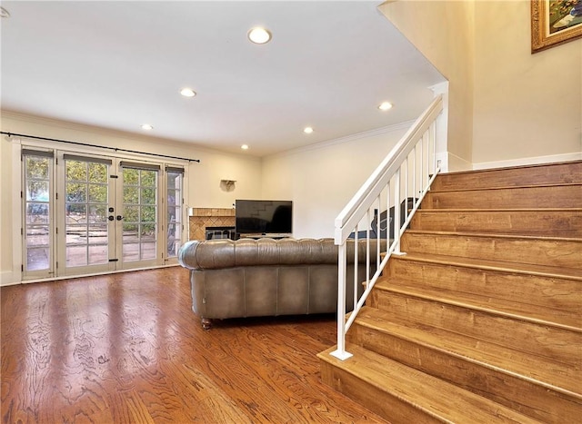 living area with recessed lighting, wood finished floors, french doors, stairway, and crown molding