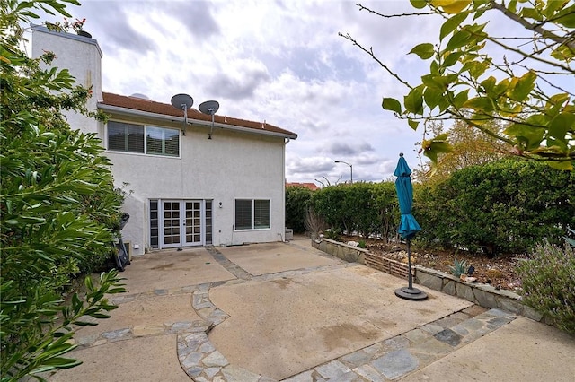 back of house featuring french doors, a patio area, and stucco siding