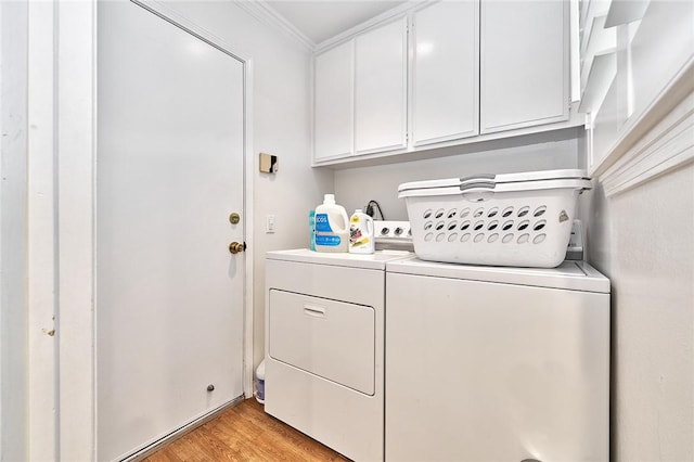 laundry room featuring cabinet space, ornamental molding, separate washer and dryer, and light wood finished floors