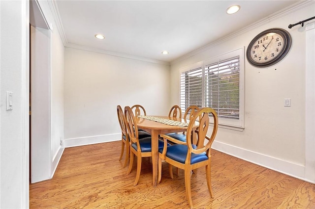 dining area featuring baseboards, ornamental molding, and light wood-style floors