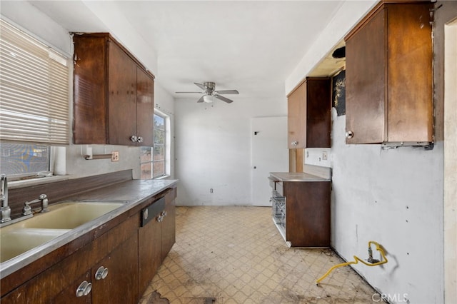 kitchen with ceiling fan, light floors, and a sink