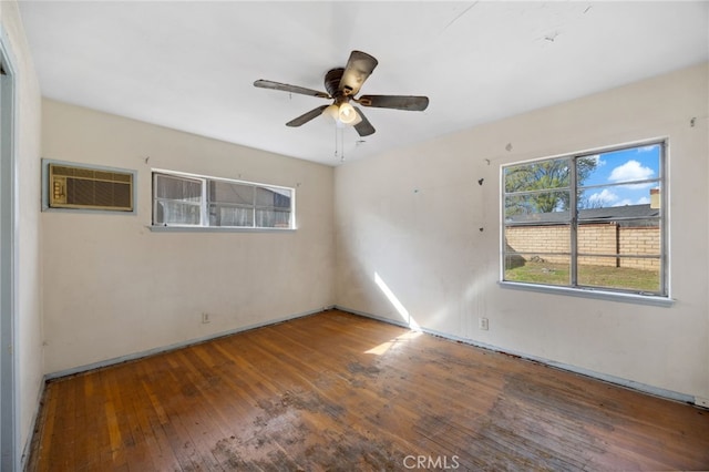 spare room featuring ceiling fan, hardwood / wood-style floors, and a wall mounted air conditioner