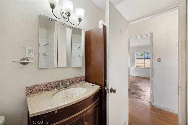 bathroom with a textured wall, wood finished floors, and vanity