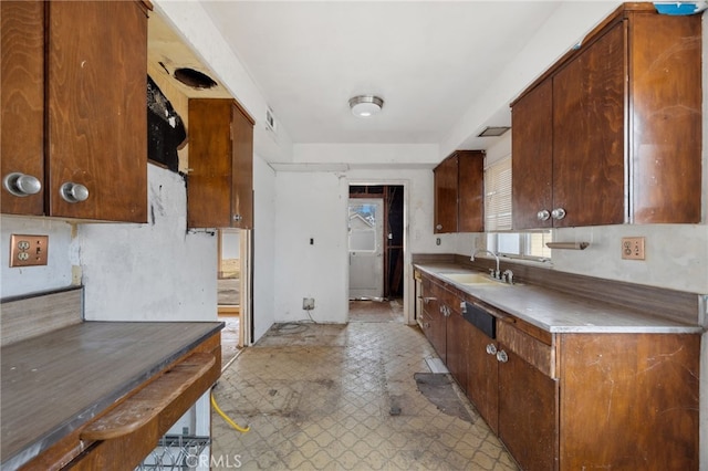 kitchen featuring light floors, light countertops, a sink, and visible vents