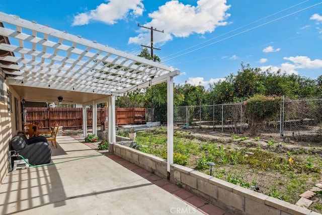 view of patio featuring ceiling fan, a fenced backyard, a garden, and a pergola