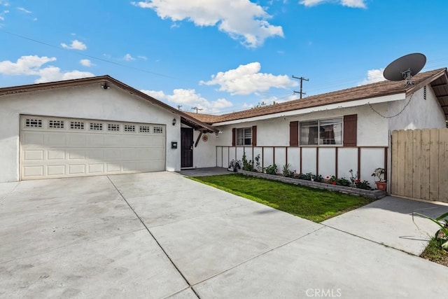 ranch-style home with a garage, fence, concrete driveway, and stucco siding