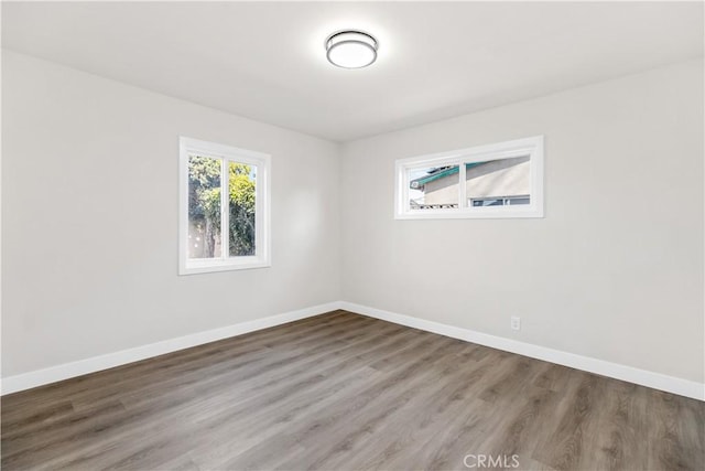 empty room featuring baseboards and wood finished floors