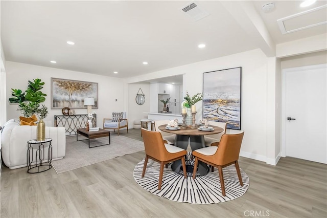 dining room featuring baseboards, light wood-style flooring, visible vents, and recessed lighting