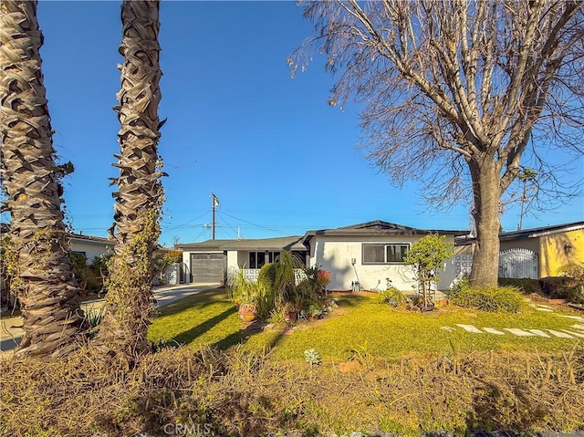 ranch-style home with an attached garage, stucco siding, and a front yard