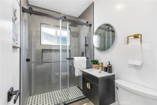 full bathroom featuring a stall shower, vanity, and toilet