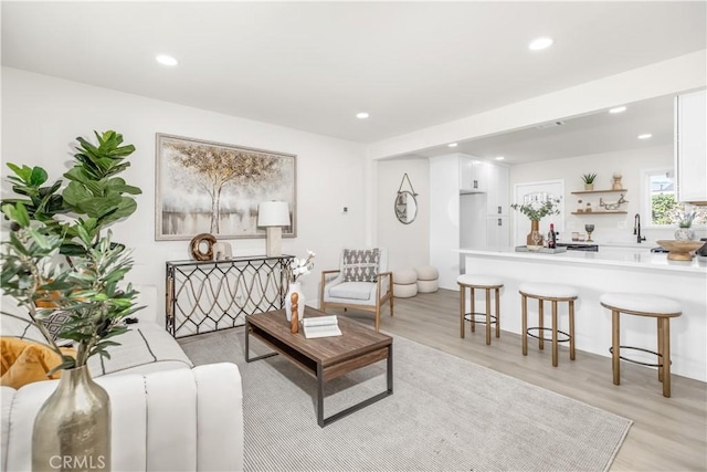 living room with light wood-type flooring and recessed lighting