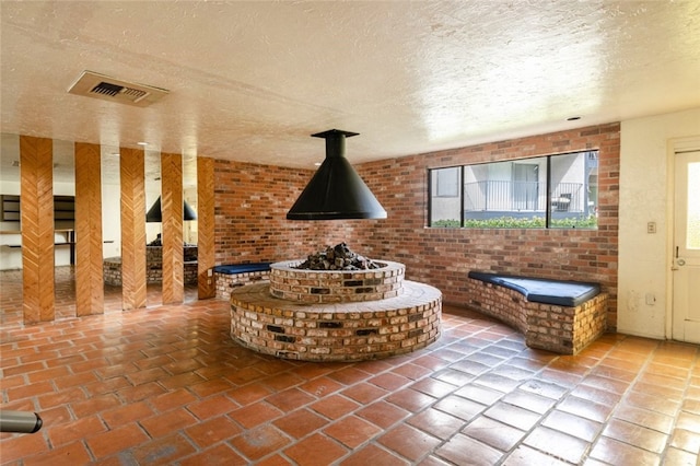 bathroom featuring visible vents, a textured ceiling, and brick floor