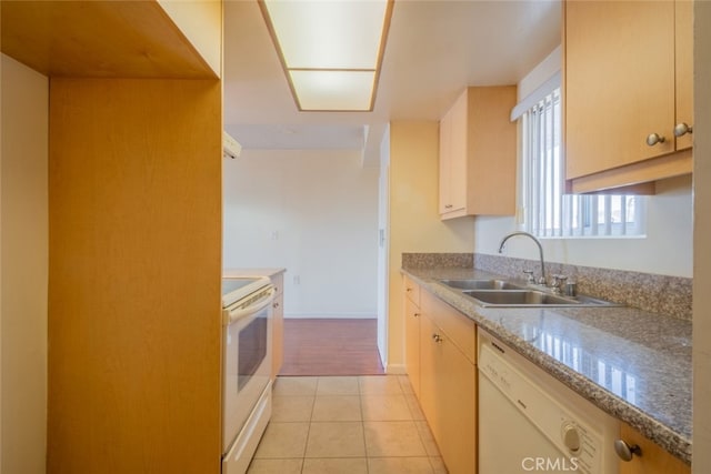 kitchen featuring a sink, white appliances, light countertops, light tile patterned floors, and baseboards