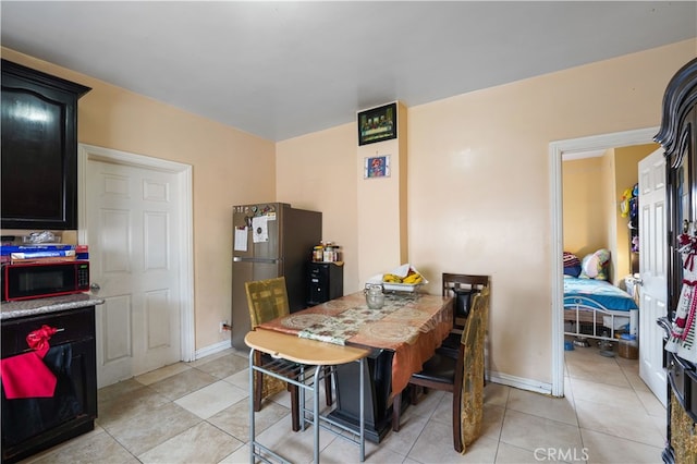 dining area featuring light tile patterned floors and baseboards