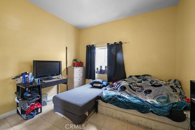 tiled bedroom featuring baseboards