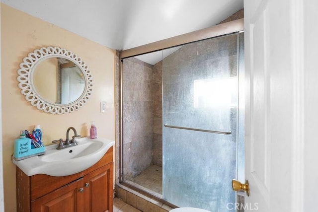 full bathroom featuring a stall shower, vanity, and vaulted ceiling