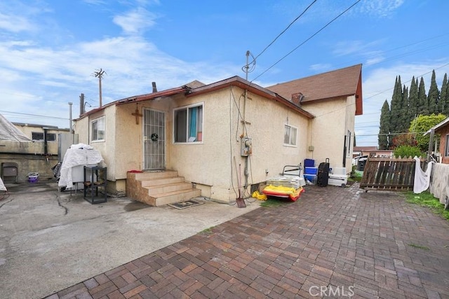 back of property with a patio area, stucco siding, and fence