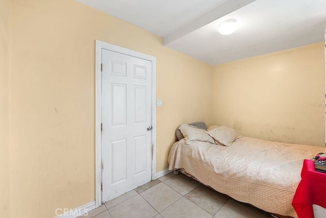 bedroom featuring light tile patterned floors and baseboards