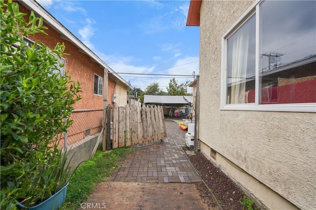 view of side of property featuring crawl space, stucco siding, and fence