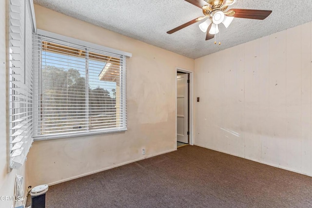 carpeted spare room with ceiling fan and a textured ceiling