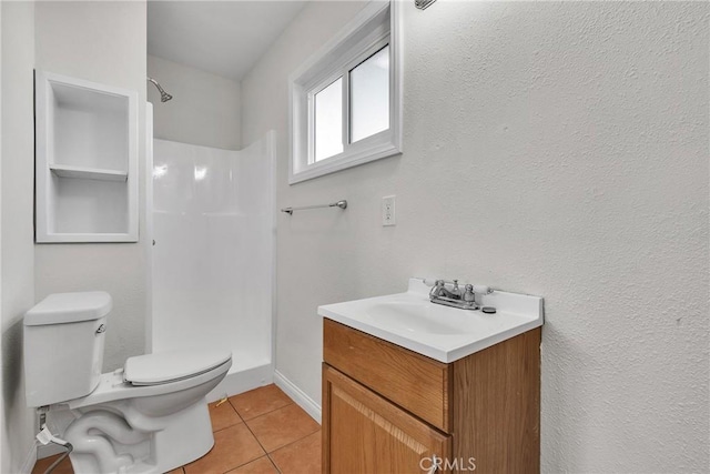 bathroom with a shower, vanity, toilet, and tile patterned floors