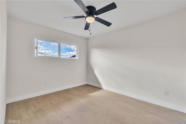 spare room with ceiling fan, wood finished floors, and baseboards