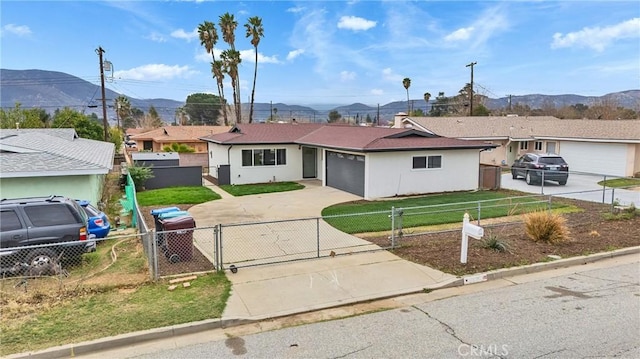 single story home with a fenced front yard, a gate, driveway, and a garage