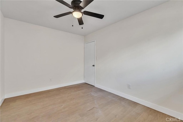 spare room featuring a ceiling fan, baseboards, and light wood finished floors