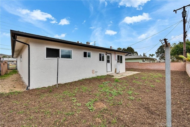 back of house with fence and stucco siding