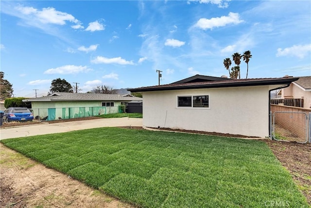 view of home's exterior featuring a yard, fence, and stucco siding