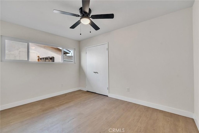 unfurnished room with a ceiling fan, baseboards, and wood finished floors