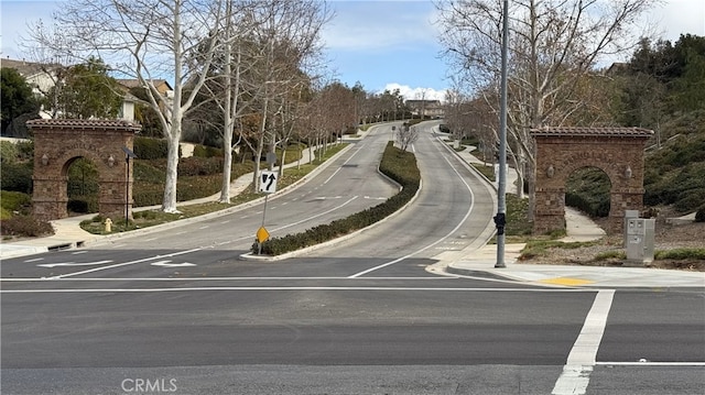 view of road featuring sidewalks, traffic signs, and curbs