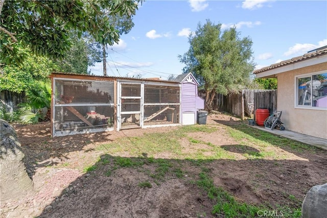 view of yard with fence, exterior structure, and an outbuilding